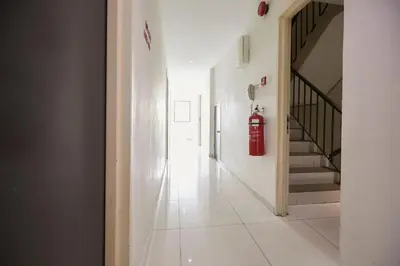a white hallway with a red fire hydrant on the wall at Le Ruiz Boutique Hotel in Kuala Lumpur