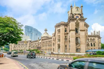 a large building with a clock tower on a street at Le Ruiz Boutique Hotel in Kuala Lumpur