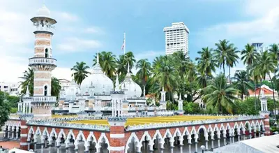 a mosque in a city with palm trees in the background at OYO 191 ML Inn Hotel in Kuala Lumpur