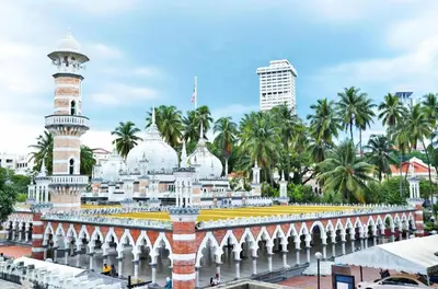a mosque in a city with palm trees at OYO 264 City Edge Hotel in Kuala Lumpur