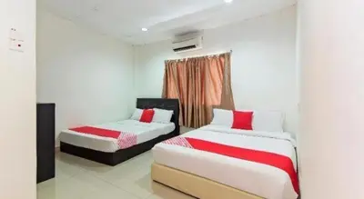 two beds in a room with red and white sheets at OYO 304 Zero Hour Hotel in Kuala Lumpur