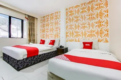 two beds in a room with red and white at OYO 89571 Eco Palace hotel in Kuala Lumpur