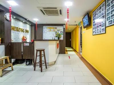 a restaurant with yellow walls and a bar with a stool at OYO 90173 Hotel Mekong in Kuala Lumpur