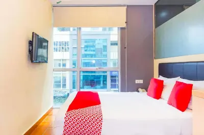a bedroom with a bed with red pillows and a window at OYO 90429 Hotel Narasindo in Kuala Lumpur