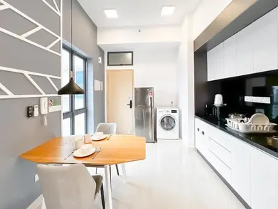 a kitchen with a wooden table and white cabinets at The Luxe by Manhattan Group in Kuala Lumpur