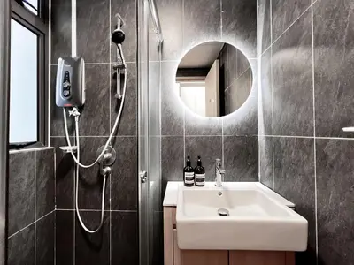 a bathroom with a shower and a sink and a mirror at The Luxe by Manhattan Group in Kuala Lumpur