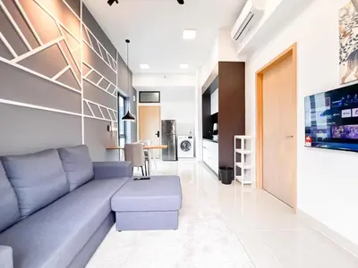 a living room with a blue couch and a kitchen at The Luxe by Manhattan Group in Kuala Lumpur