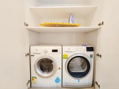 a washing machine and a washer in a laundry room at Lucentia Residences by Manhattan Group in Kuala Lumpur