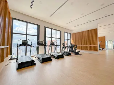 a gym with several treadmills in a room with windows at Lucentia Residences by Manhattan Group in Kuala Lumpur