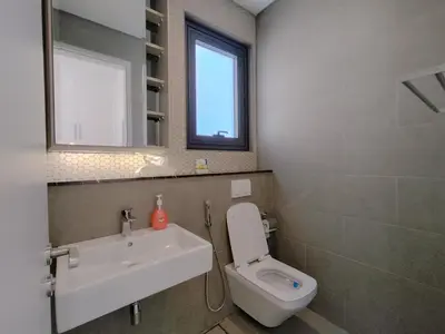 a bathroom with a sink and a toilet and a mirror at Lucentia Residences by Manhattan Group in Kuala Lumpur