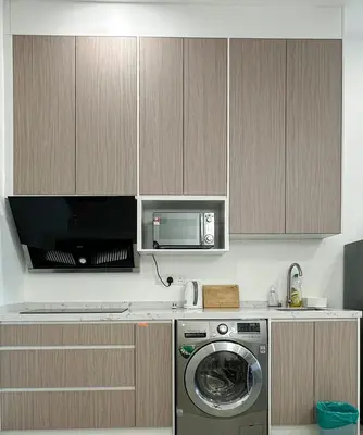 a kitchen with a washing machine and a microwave at Taragon Bukit Bintang City Centre in Kuala Lumpur