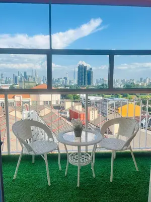a table and chairs on a balcony with a view of a city at Diamond Suite Homestay in Kuala Lumpur