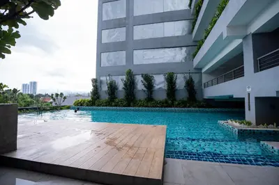 a swimming pool in front of a building at Neu Suites By Cozy Unit L30RB 2PAX near KLCC & Jelatek LRT in Kuala Lumpur