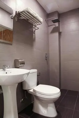 a bathroom with a white toilet and a sink at Hotel Mezzo in Kuala Lumpur