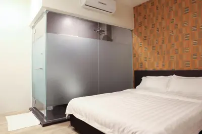 a bedroom with a white bed and a glass wall at Hotel Mezzo in Kuala Lumpur