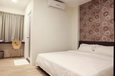 a bedroom with a large white bed and a chair at Hotel Mezzo in Kuala Lumpur