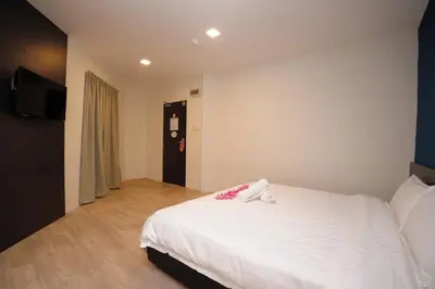 a bedroom with a white bed and a flat screen tv at Hotel Mezzo in Kuala Lumpur