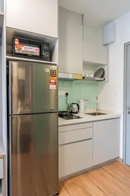 a kitchen with a stainless steel refrigerator and white cabinets at The Riv at Riveria City KL Sentral KLCC view16 in Kuala Lumpur