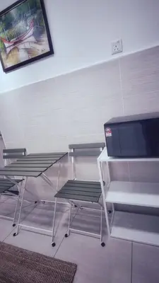 a room with two chairs and a table and a tv at KLCC Legasi Executive Suite Apartment in Kuala Lumpur
