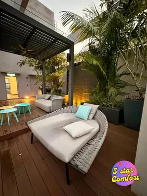 a patio with a white couch and a table at 5 Star Comfort Riveria City KL Sentral 4 pax infinity pool in Kuala Lumpur