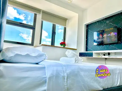 a white bed in a room with windows at 5 Star Comfort Riveria City KL Sentral 4 pax infinity pool in Kuala Lumpur