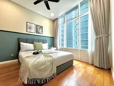 a bedroom with a large bed and a large window at Sky Suites Deluxe 3BR Suite at KLCC in Kuala Lumpur