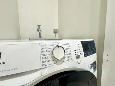 a washing machine with a sink on top of it at Sky Suites Deluxe 3BR Suite at KLCC in Kuala Lumpur