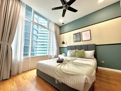 a bedroom with a large bed with a ceiling fan at Sky Suites Deluxe 3BR Suite at KLCC in Kuala Lumpur