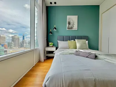 a bedroom with a blue wall and a large window at Sky Suites Wonder 2BR Suite KLCC View in Kuala Lumpur
