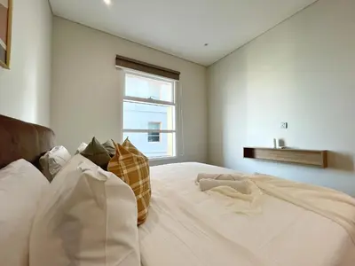 a bedroom with a large white bed with a window at Sky Suites Unique 3BR Suite KLCC View in Kuala Lumpur