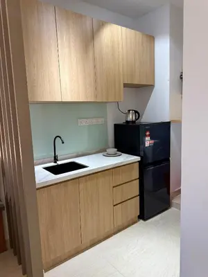 a kitchen with a sink and a black refrigerator at Klcc view residences in Kuala Lumpur