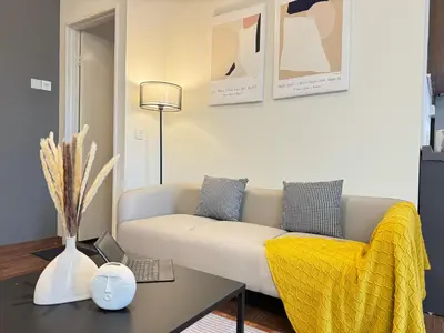 a living room with a white couch and a table at X - The Thomas Bangsar South Midvalley LRT Kerinchi in Kuala Lumpur