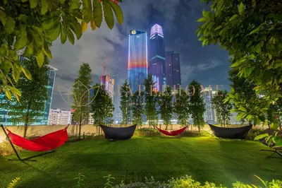 a garden with hammocks in a city at night at Agile Premier Suites Kuala Lumpur in Kuala Lumpur