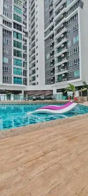 a pool with a pink and purple umbrella in front of some buildings at MH Platinum 2 Homestay 3Bedroom in Kuala Lumpur