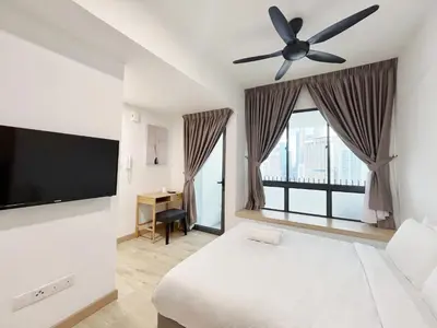a bedroom with a bed and a flat screen tv at The Colony Infinitum By Happy Stay in Kuala Lumpur