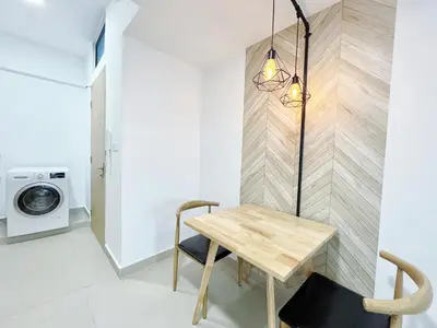 a small apartment with a wooden table and a washing machine at The Colony Infinitum By Happy Stay in Kuala Lumpur