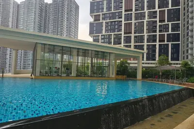 a large swimming pool with tall buildings in the background at Elegant 1BR in OOAK Suites, Mont Kiara KL - Walk to Malls & Dining in Kuala Lumpur