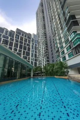 a large swimming pool in front of tall buildings at Elegant 1BR in OOAK Suites, Mont Kiara KL - Walk to Malls & Dining in Kuala Lumpur