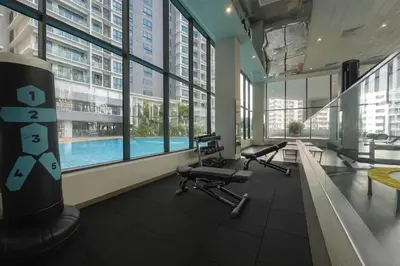 a gym with a swimming pool in a building at Elegant 1BR in OOAK Suites, Mont Kiara KL - Walk to Malls & Dining in Kuala Lumpur