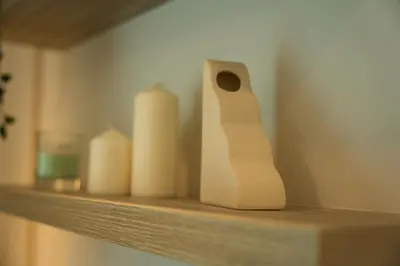a shelf with a bunch of white candles on it at Elegant 1BR in OOAK Suites, Mont Kiara KL - Walk to Malls & Dining in Kuala Lumpur