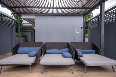 two wicker chairs with blue pillows on a patio at Neu Suites By Cozy Unit L30RA 2-3PAX near KLCC & Jelatek LRT in Kuala Lumpur