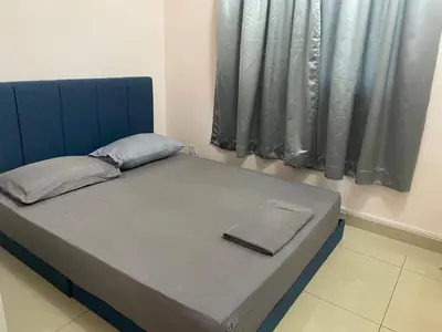 a bed with a blue headboard with a notebook on it at Azmaya homestay in Kuala Lumpur