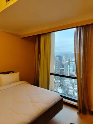 a bedroom with a bed and a large window at Penthouse Duplex with KLCC Views At Times Square in Kuala Lumpur
