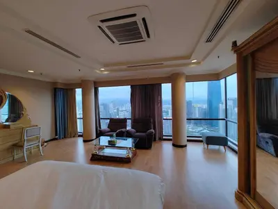 a bedroom with a bed and a living room with a view at Penthouse Duplex with KLCC Views At Times Square in Kuala Lumpur