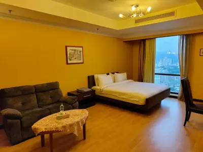 a hotel room with a bed and a couch at Penthouse Duplex with KLCC Views At Times Square in Kuala Lumpur