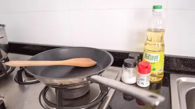 a frying pan on a stove with a wooden spoon at Spacious Family Apt 3-Min Walk to KLCC MRT RO Water Baby Crib Home Cinema Projector in Kuala Lumpur