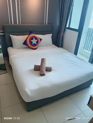 a bed with a superman pillow and a toy on it at The luxe suite service KLCC in Kuala Lumpur