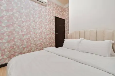 a bedroom with a white bed and a patterned wall at Retreat In The Heart of KLCC, The Corinthians in Kuala Lumpur