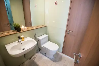 a bathroom with a toilet and a sink and a mirror at Soho Suites KLCC by Minsha Homes in Kuala Lumpur