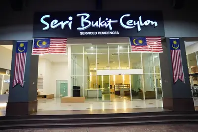 a sears building with flags in front of it at The Luxe stay Bukit Bintang in Kuala Lumpur